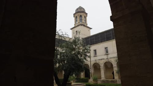 slow revealing shot of a courtyard with various archways within a french university