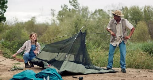 People Setting Up Tent at Rural Campsite