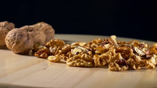Close-up of Shelled and Unshelled Walnuts on Wood