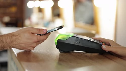 Unerkennbarer Mann, der bargeldlose elektronisch Geldbörsen auf dem Smartphone (NFC-Technologie) zur Bezahlung von Bestellungen verwendet