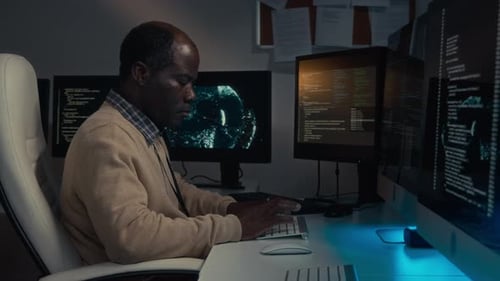 Man Coding at Computer Workstation at Night