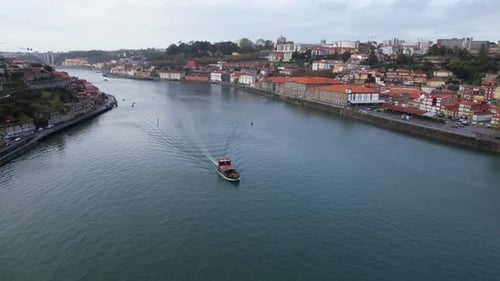 Rabelo boat sailing on Douro River, Porto, Portugal. Aerial flying forward