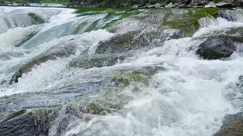 Stormy streams of water and waterfalls of a mountain river.
