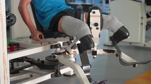 Disabled athletic exercising on machine in fitness gym 4k