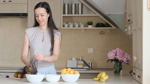 Una mujer morena pone fruta en una bolsa ecológica