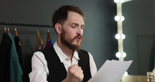 Actor with script rehearsing his lines in dressing room