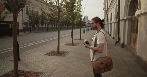 Male Photographer Taking Photos of Town on Vintage Camera