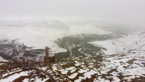 Drone View of Ancient Ani City Walls and Tower Overlooking the Snowy Akhurian River Gorge