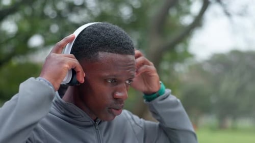 Fitness, park and black man with headphones for music, playlist and radio for workout