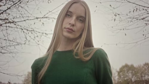 Model posing for photoshoot in nature wearing green