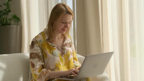 Concentrated Lady Employee Types Data on Website Via Laptop