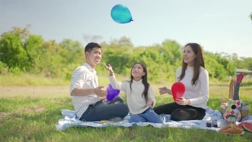 Family Picnic Playing with Balloons in the Park