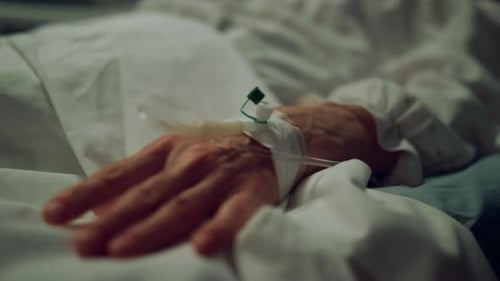 Hand with iv drip in hospital ward bed close up healthcare treatment