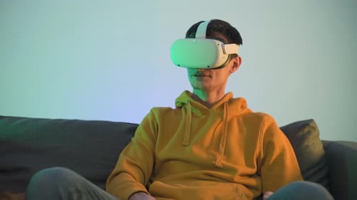 Adult Using Virtual Reality Headset on Couch