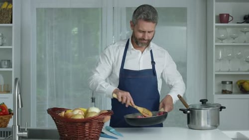 Man Cooking Ground Meat in a Kitchen