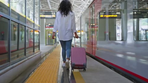 Girl with Suitcase Walking on the Station Platform