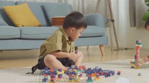 Children Play With Building Blocks Together at Home