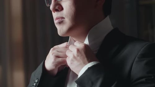 Close Up Of A Man With Glasses Wearing Jacket And Buttoning White Classic Shirt