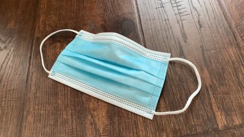 Light Blue Surgical Mask on Wooden Surface