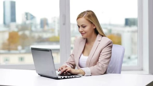 Young businesswoman typing on laptop computer at office workplace technology