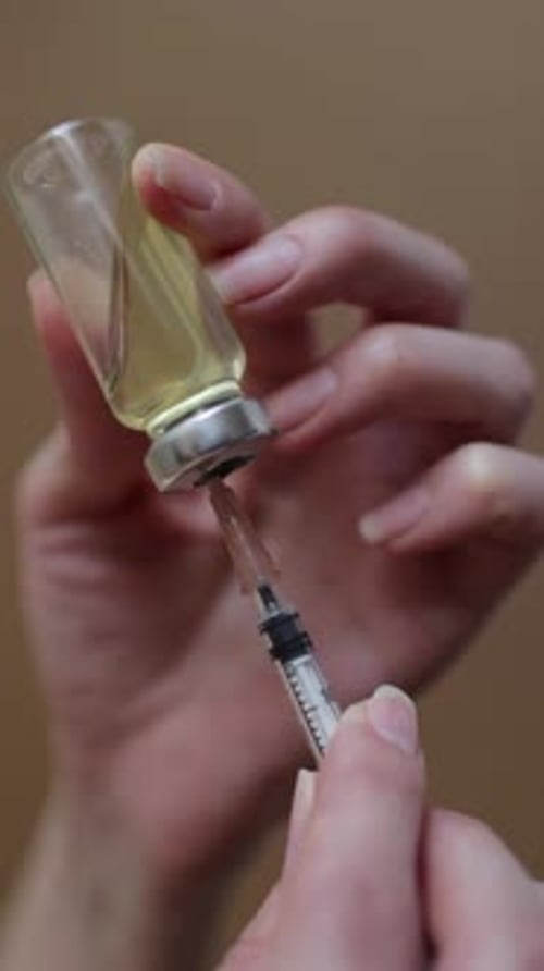 Female Hands Inject the Solution Into a Vial of Vaccine with a Syringe Vertical Video