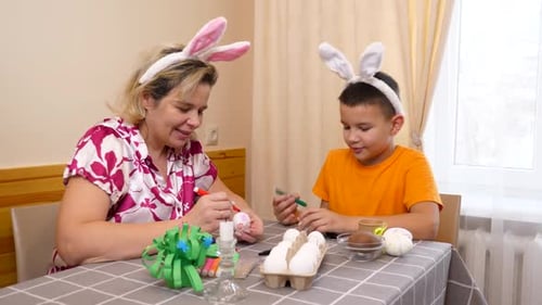 16Mother and son celebrate Easter. They prepare a basket, paint eggs and have fun.
