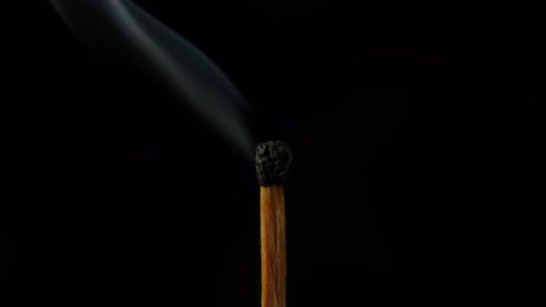 Burning Matchstick Close Up Against Black Background