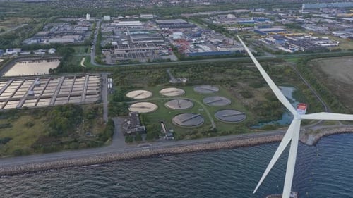 High-angle: wastewater facility and wind turbine, efficient clean design.