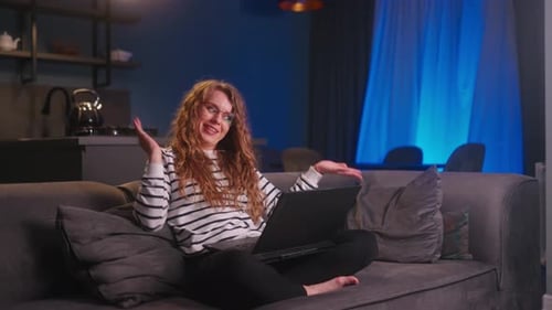 Young Woman Video Conferencing On Laptop At Home