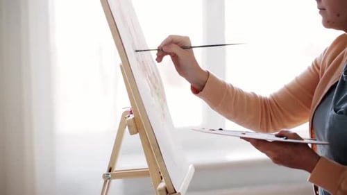 Woman Painting on Canvas on Easel in Studio