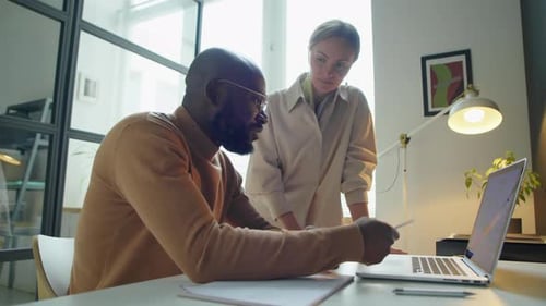 Business Colleagues Discussing Project on Laptop in Office