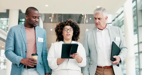 Business Team Walking and Discussing Tablet in Office