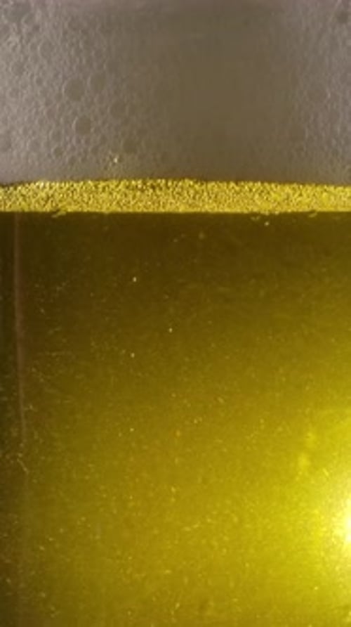 Vertical of Golden Beer Fizzling in Mug