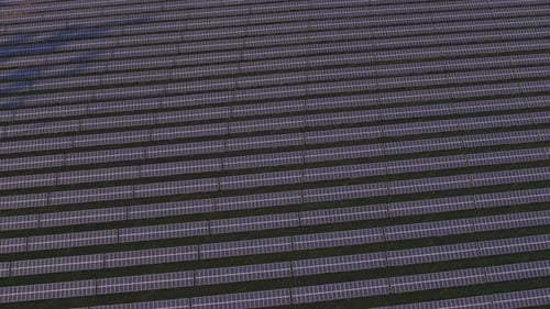 view from a drone on solar energy collectors at sunset