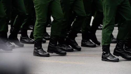 Closeup of Uniformed Personnel Marching in Unison Green Trousers and Black Combat Boots Striking the