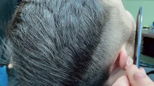 Barber Cutting Man's Hair in Barbershop, Close Up