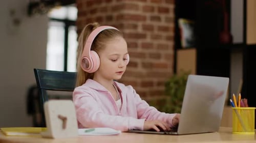 Child Using Laptop with Headphones in Home Setting