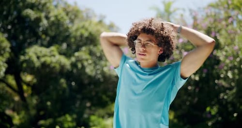 Man Stretching Arms in Park on Sunny Day
