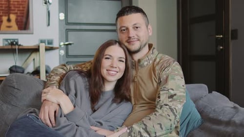 Loving Couple Embrace on Sofa Inside Home