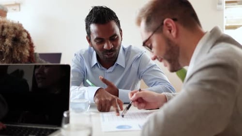Empresarios multiétnicos que trabajan en una oficina bancaria analizando datos: concepto financiero empresarial