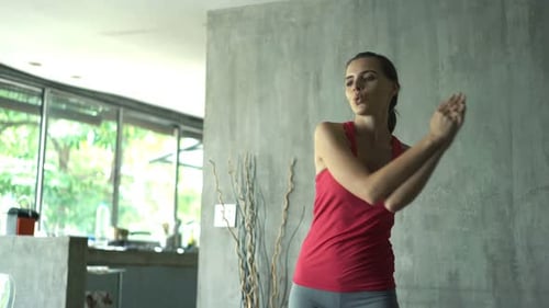 Woman indoors doing arm stretches and yoga