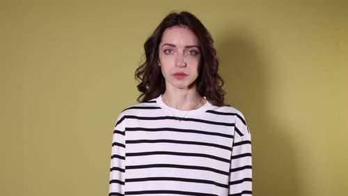 Woman making stop gesture on yellow background