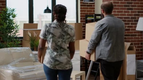 Couple Moving Cardboard Boxes into New Apartment
