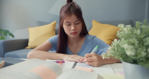 Young Woman Studies at Home with Laptop
