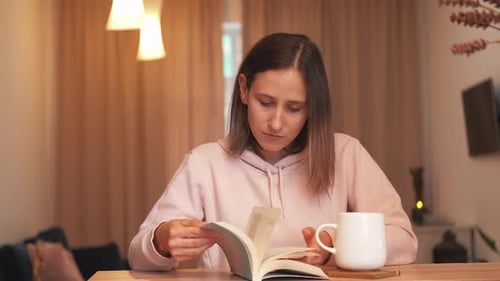 Woman Reading a Book with Coffee Indoors