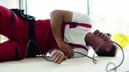 Injured construction worker lying on the floor indoors