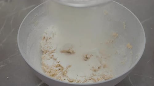 Flour being added to make dough in bowl