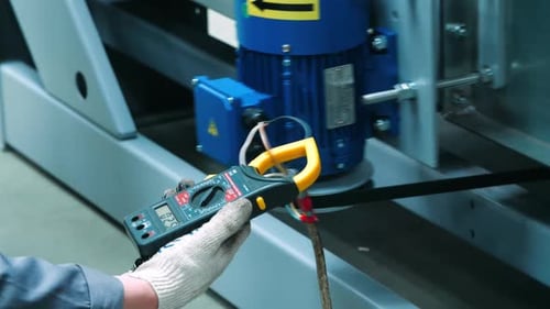 Electrical Technician Measuring Voltage on Machine Wires