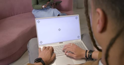 La pantalla en blanco del portátil que muestra marcadores incita al mecanógrafo a escribir en el regazo, tocando entre pares en la tableta