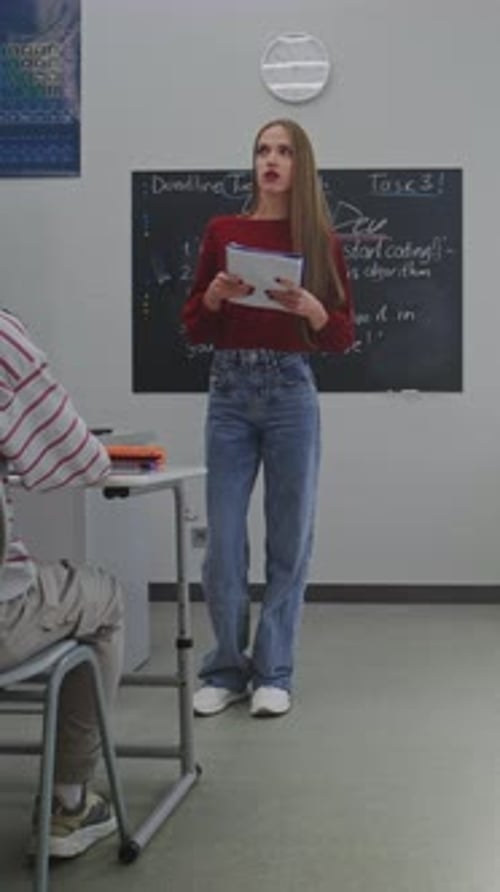 Female Teacher Explains Programming to Student in Classroom